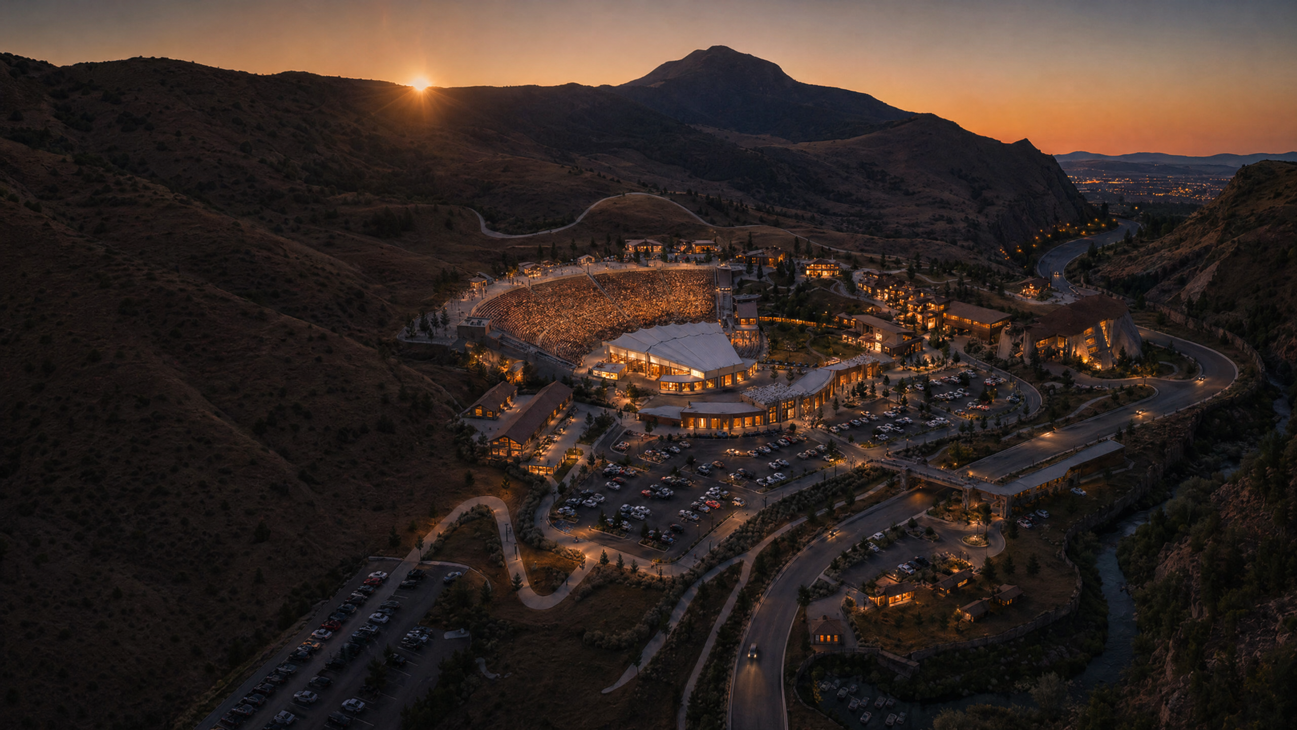 Vesper Amphitheater aerial night rendering — illuminated venue nestled in Provo Canyon with mountain backdrop at sunset
